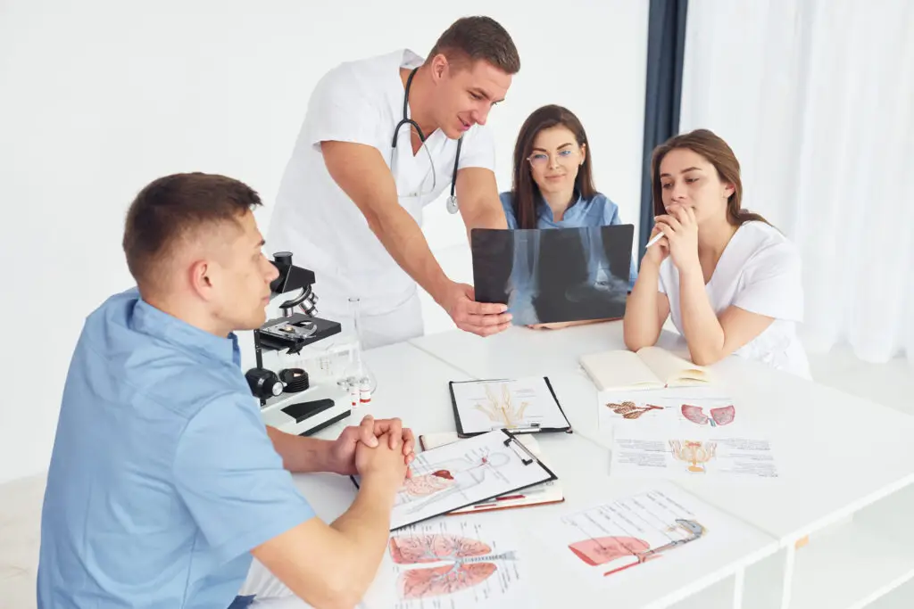 man with microscope group of young doctors is working 16728455 man with microscope group of young doctors is working 16728455